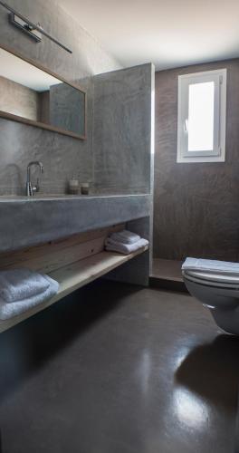 エルムポリにあるThe Loft Hutのバスルーム(洗面台、トイレ付)、窓が備わります。