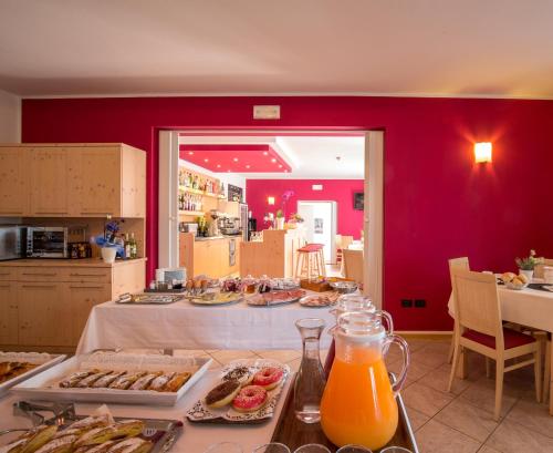een keuken met een tafel met eten en sinaasappelsap bij Hotel Da Remo in Tenna 