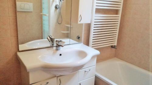 La salle de bains est pourvue d'un lavabo blanc et d'une baignoire. dans l'établissement Appartamenti Paradiso, à Venise