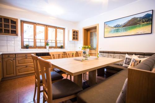 cocina y comedor con mesa de madera y sillas en Grafenberg Chalet, en Wagrain