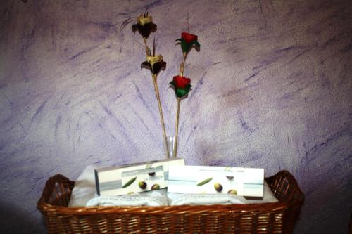 a basket with two flowers and two candles on it at Hotel Carvajal in Torrejón el Rubio