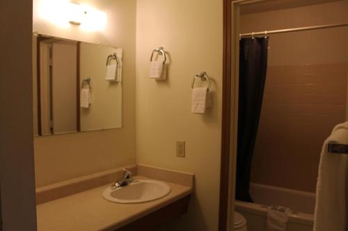 a bathroom with a sink and a mirror and a shower at Silver Sands Motel in Florence
