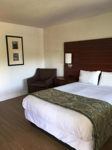 a hotel room with a large bed and a chair at Diablo Mountain Inn Walnut Creek in Walnut Creek