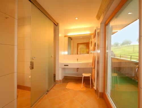uma casa de banho com um lavatório e um espelho em Landhotel Kielhuberhof em Ramsau am Dachstein