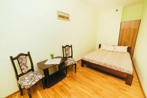 リヴィウにあるApartment on brativ Rohatyntsiv 3のベッドルーム1室(ベッド1台、テーブル、椅子付)