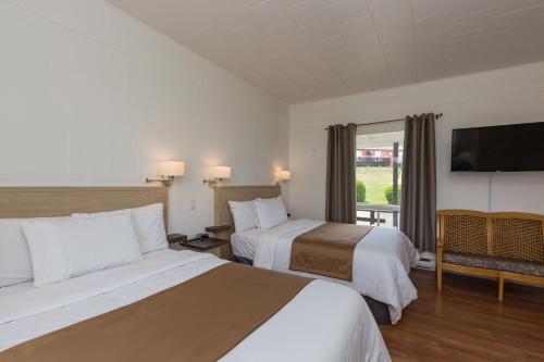 Ένα ή περισσότερα κρεβάτια σε δωμάτιο στο Motel au Fleuve d'Argent