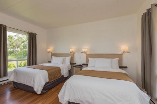 Ένα ή περισσότερα κρεβάτια σε δωμάτιο στο Motel au Fleuve d'Argent