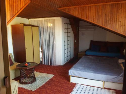 a small bedroom with a bed and a table at Apartman Amalija in Gornji Karin