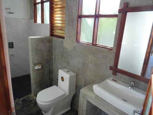 y baño con aseo y lavamanos. en Nelu Villa Sigiriya en Sigiriya