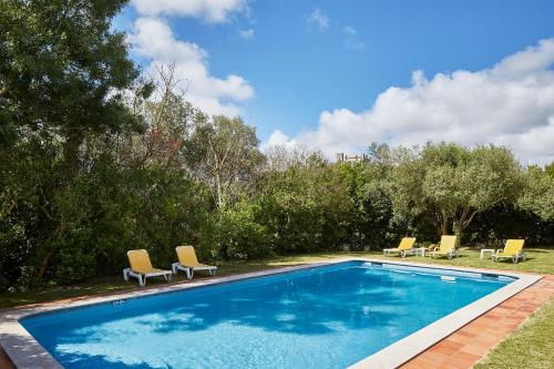 a swimming pool with lounge chairs next to at Casa D Obidos in Óbidos