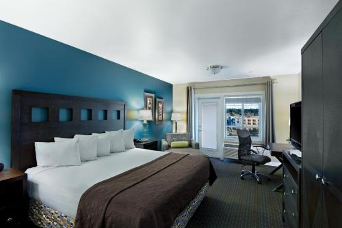 Habitación de hotel con cama grande y escritorio. en Oxford Suites Silverdale en Silverdale
