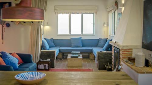 a living room with a blue couch and a fireplace at Magoito1 in Sintra