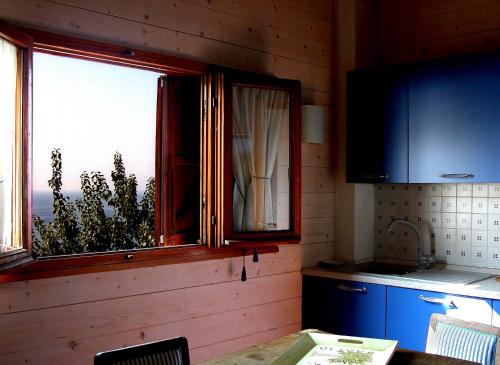 切萊利古雷的住宿－納塔迪蒙特泰伯鄉村民宿，厨房设有窗户、桌子和柜台
