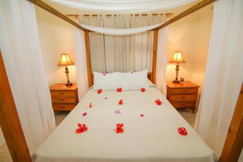 a bedroom with a bed with red flowers on it at Catcha Falling Star in Negril