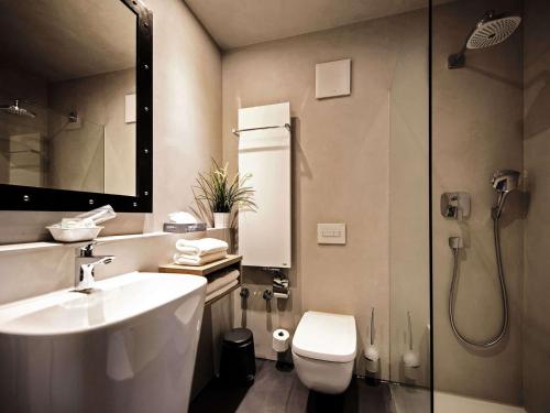 ein Bad mit einem WC, einem Waschbecken und einer Dusche in der Unterkunft alexxanders Hotel & Boardinghouse, Restaurant in Chemnitz