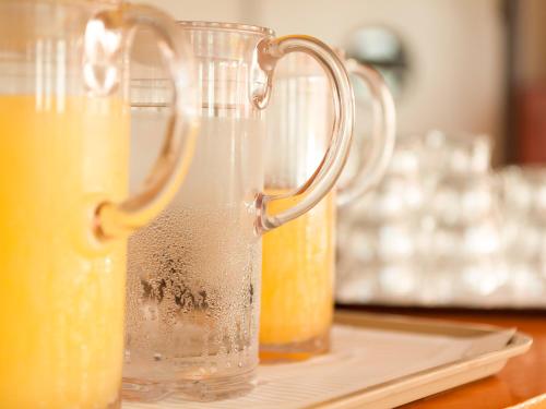 two glasses of orange juice sitting on a table at Cabo Verde Hotel in Mati