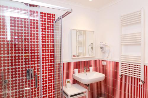 baño rojo con lavabo y ducha en Maison Ro' en Meta