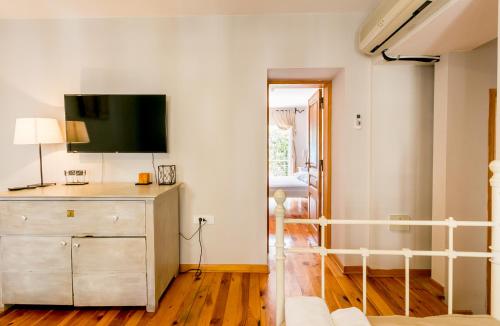 a bedroom with a dresser with a tv on the wall at Stanica B&B in Herceg-Novi