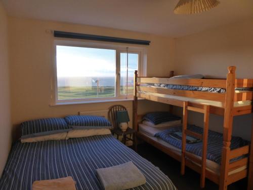 two bunk beds in a room with a window at Longbeach- Adults Only in Newquay