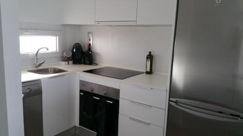 eine kleine Küche mit Spüle und Kühlschrank in der Unterkunft Hilly's Place in Roldán