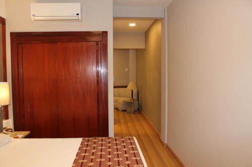 a room with a bed and a wooden door at Bourbon Londrina Hotel in Londrina