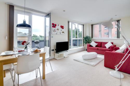 a living room with a red couch and a table at The Class Place in Birmingham