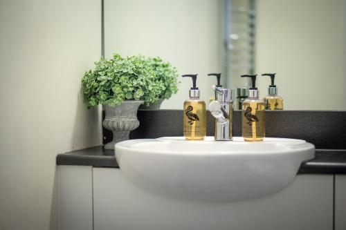a bathroom sink with four faucets and a mirror at The Class Place in Birmingham