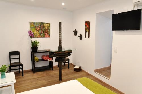 a living room with a table and a tv on a wall at Sleep In Bucelas in Bucelas