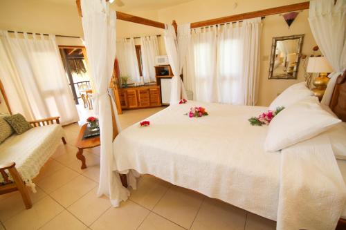 a bedroom with a white bed with flowers on it at Catcha Falling Star in Negril