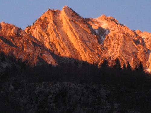 a mountain with the sun shining on it at Apartma pod Rožem in Soča