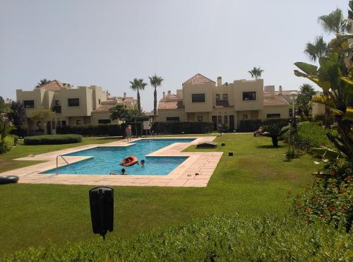 a swimming pool in a yard next to some houses at Casa Rosie in Los Alcázares