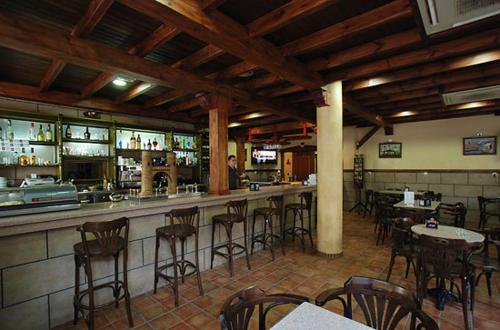 a bar in a restaurant with tables and chairs at Hostal el Puente in Tabernas