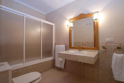 bagno con lavandino, servizi igienici e specchio di Hostal el Puente a Tabernas