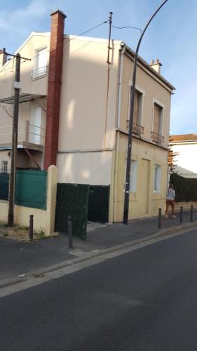 osoba idąca ulicą obok budynku w obiekcie Chambres à PARIS w mieście Ivry-sur-Seine