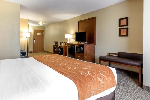 a hotel room with a bed and a flat screen tv at Comfort Suites Johnson Creek Conference Center in Johnson Creek