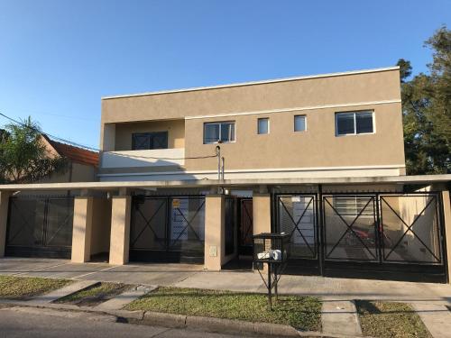 a building with glass doors in front of it at Mendoza Apartments Ezeiza Airport in Luis Guillón