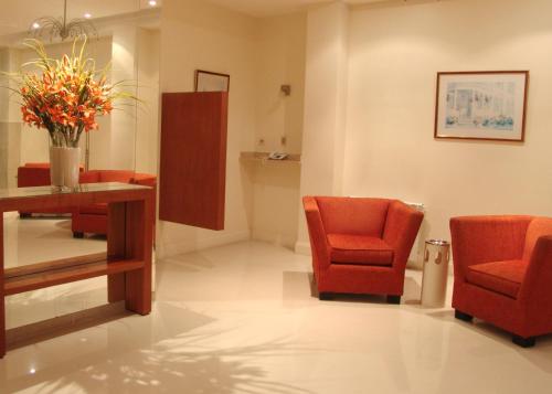a waiting room with orange chairs and a table at Gran Hotel Skorpios in Mar del Plata