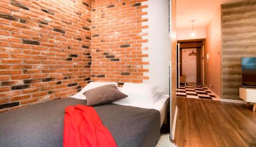 una camera da letto con un muro di mattoni e un letto di Prestigious Main Square Apartment a Cracovia