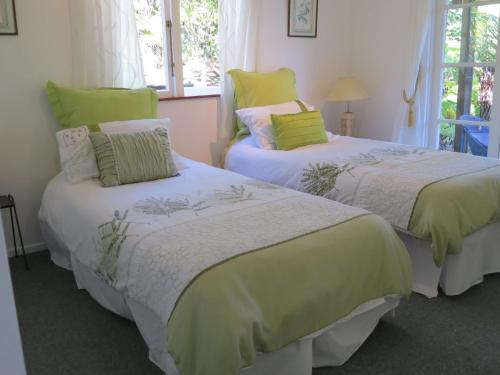 duas camas sentadas uma ao lado da outra num quarto em Coromandel Eco Sanctuary em Coromandel Town
