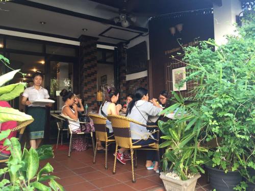 a group of people sitting at tables in a restaurant at Vientiane SP Hotel in Vientiane