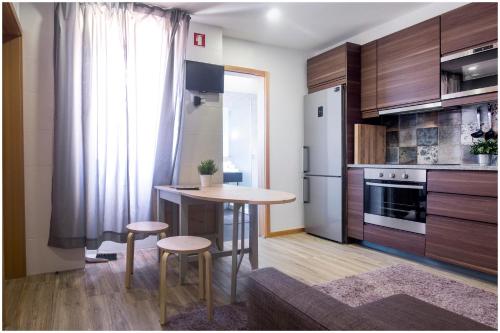 a kitchen with a table and stools in a room at SUITE T1 Junto ao Mar in Furadouro
