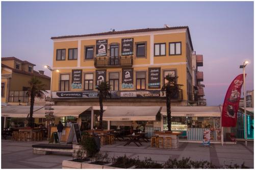 a yellow building with tables and chairs in front of it at SUITE T1 Junto ao Mar in Furadouro