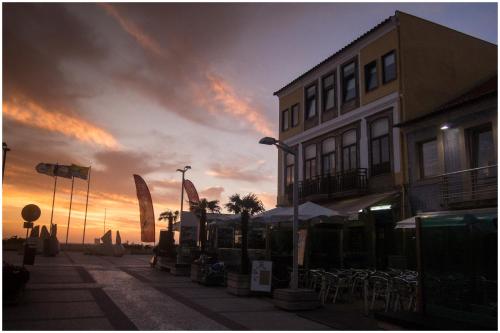 a city street with a building and a sunset at SUITE T1 Junto ao Mar in Furadouro