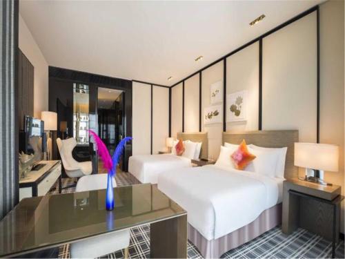 a hotel room with two beds and a desk at Yumi Apartment Lida Plaza Branch in Guangzhou