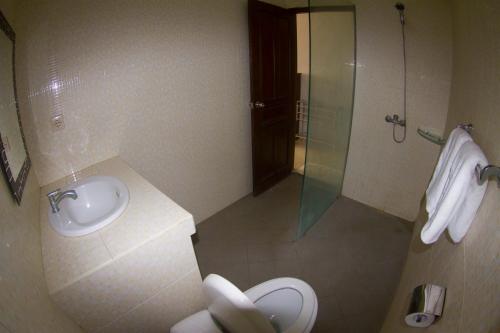 a bathroom with a toilet and a glass shower at Ropik & Alik Home Stay in Uluwatu