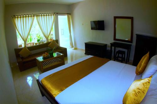 ein Schlafzimmer mit einem großen Bett und ein Wohnzimmer in der Unterkunft Ropik & Alik Home Stay in Uluwatu