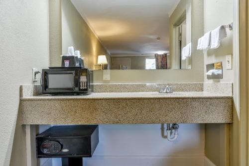 a bathroom with a sink and a microwave at Wake Inn in Raleigh