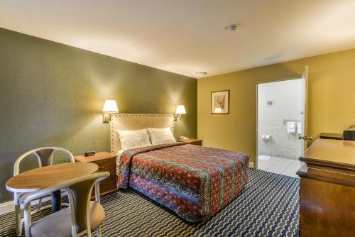 a hotel room with a bed and a bathroom at Wake Inn in Raleigh