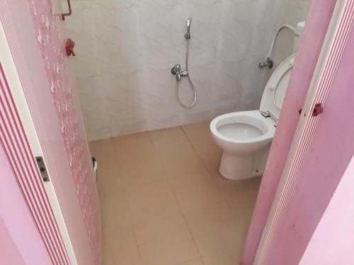 a bathroom with a toilet and a shower at Arun Cottages in Mahabalipuram