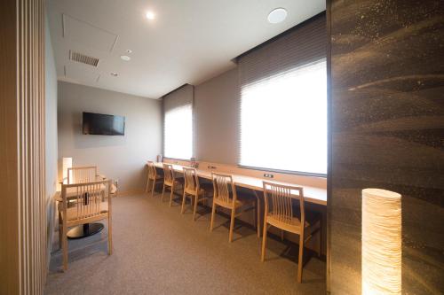 a conference room with chairs and a table and a window at Dormy Inn Izumo in Izumo